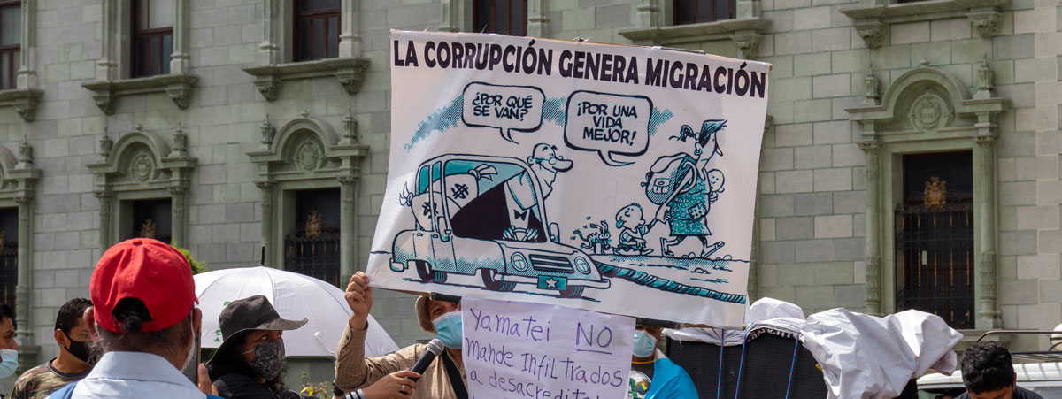 Image of a banner that says 'Corruption causes migration' in Spanish