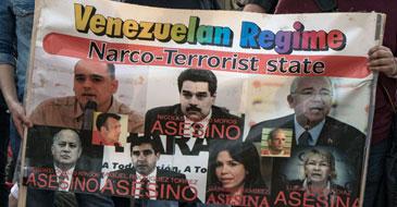 Protest banner labeling Maduro and others as "assassins"